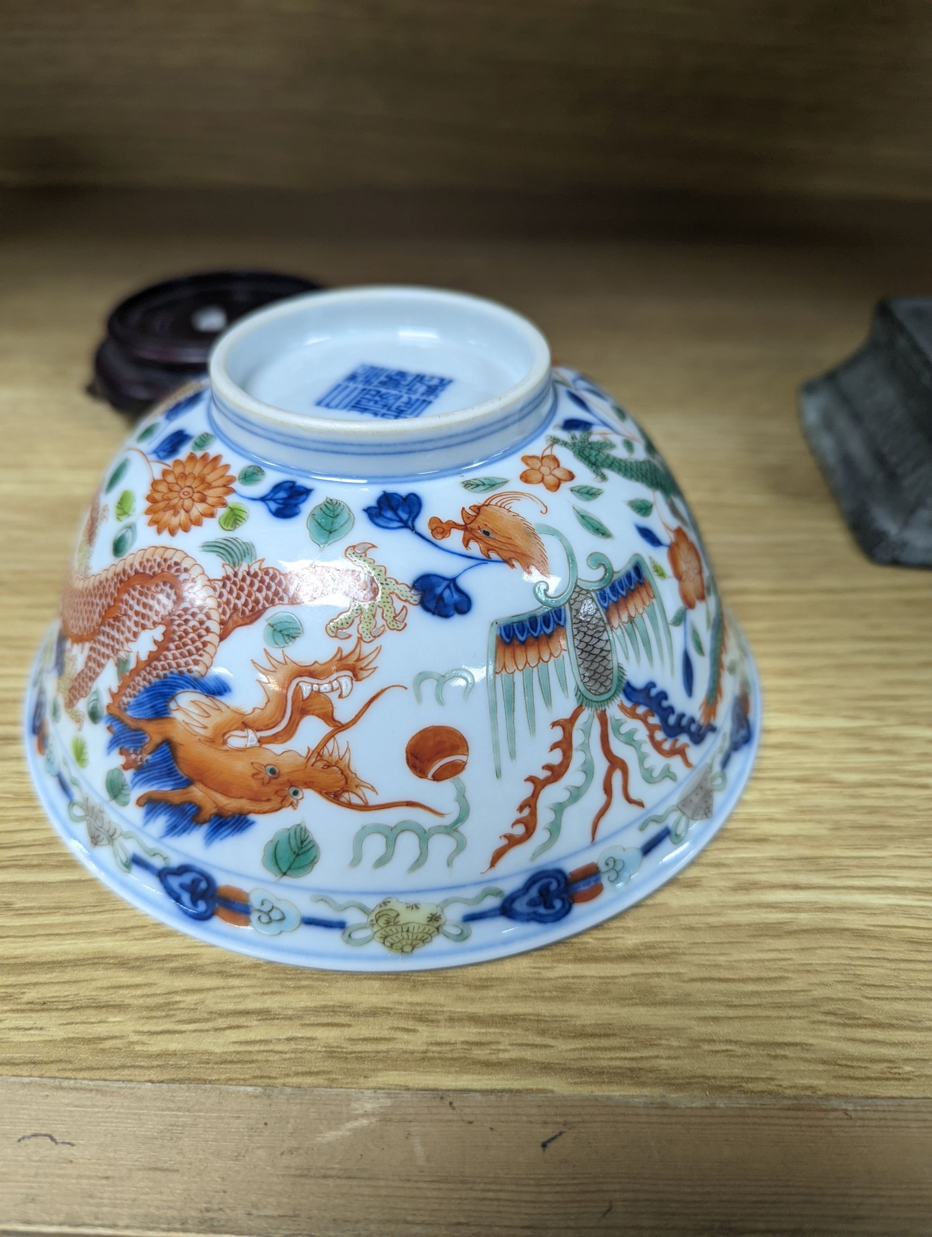 A Wucai bowl, dragon and flamingo pearl decoration, Jiaqing mark, on wood stand. 16cm diameter